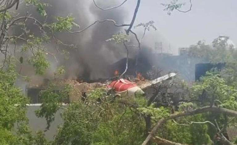Emergency crews respond to a small plane crash on the runway at Ahmedabad Airport, halting flights temporarily.