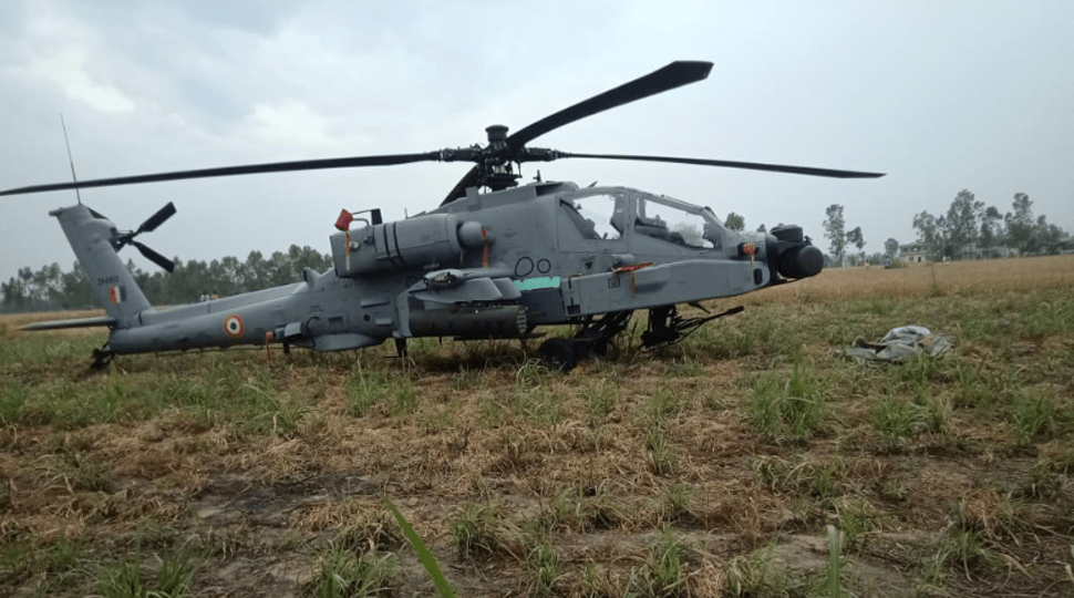 IAF Apache helicopter seen after emergency landing in Pathankot field; defence personnel inspecting aircraft for technical issues.