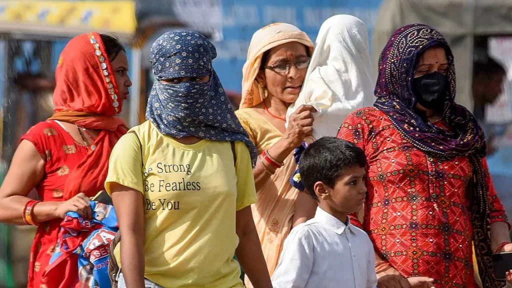 Delhi residents use scarves and umbrellas to escape extreme heat.