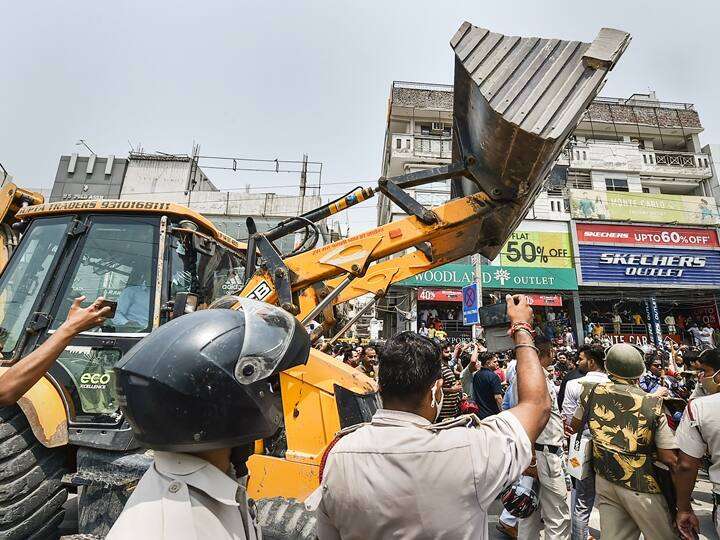 Greater Noida Authority officials conducting an anti-encroachment drive, clearing illegal vendors and structures from a busy market area.