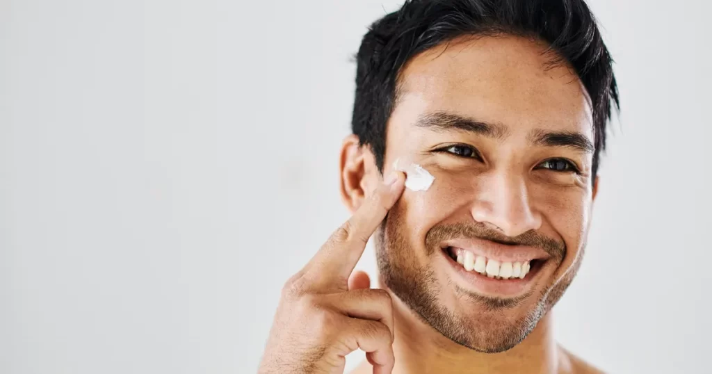Man applying moisturizer as part of daily skincare routine